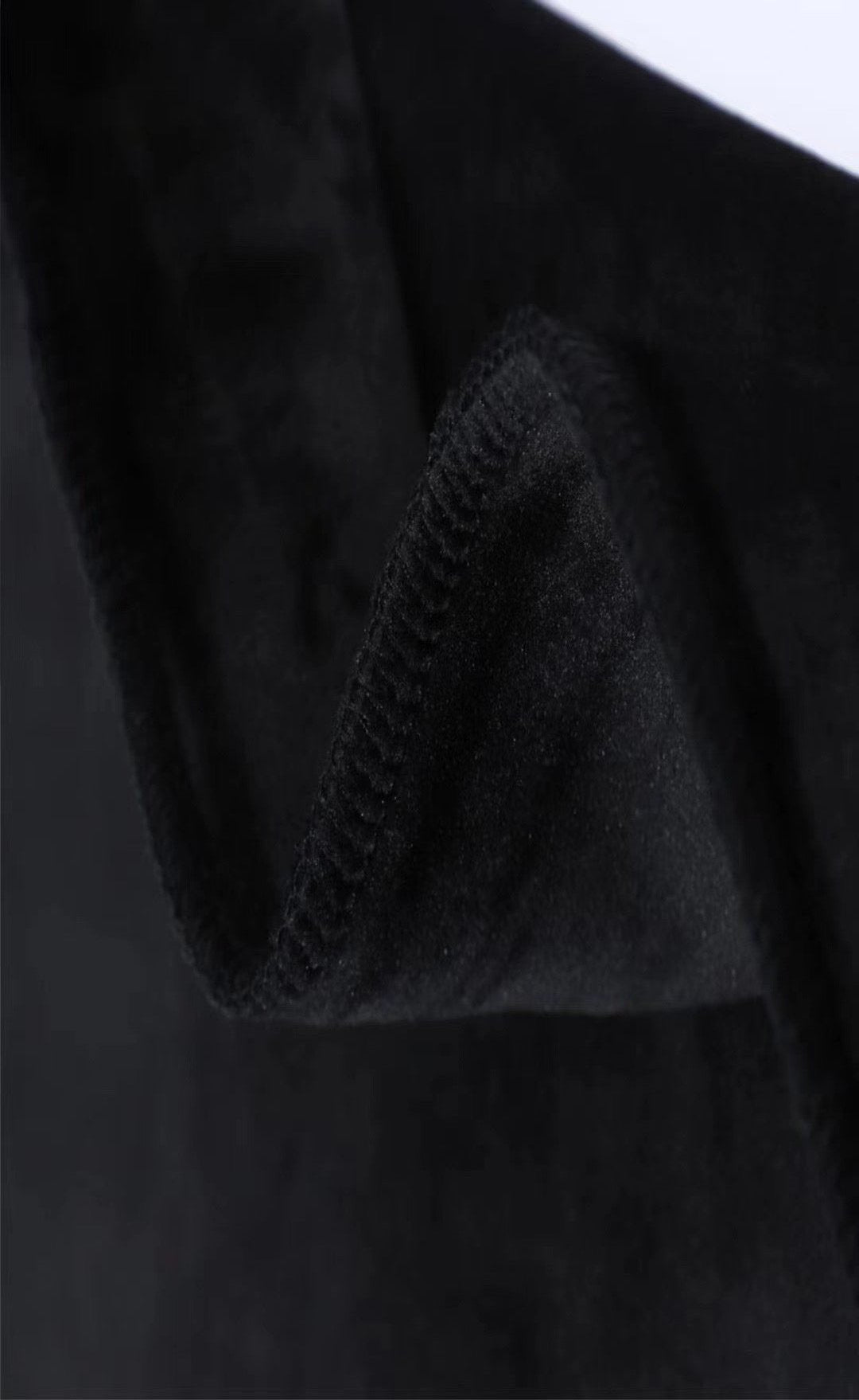 Close-up of soft black cashmere fabric showcasing its luxurious texture and quality finish.